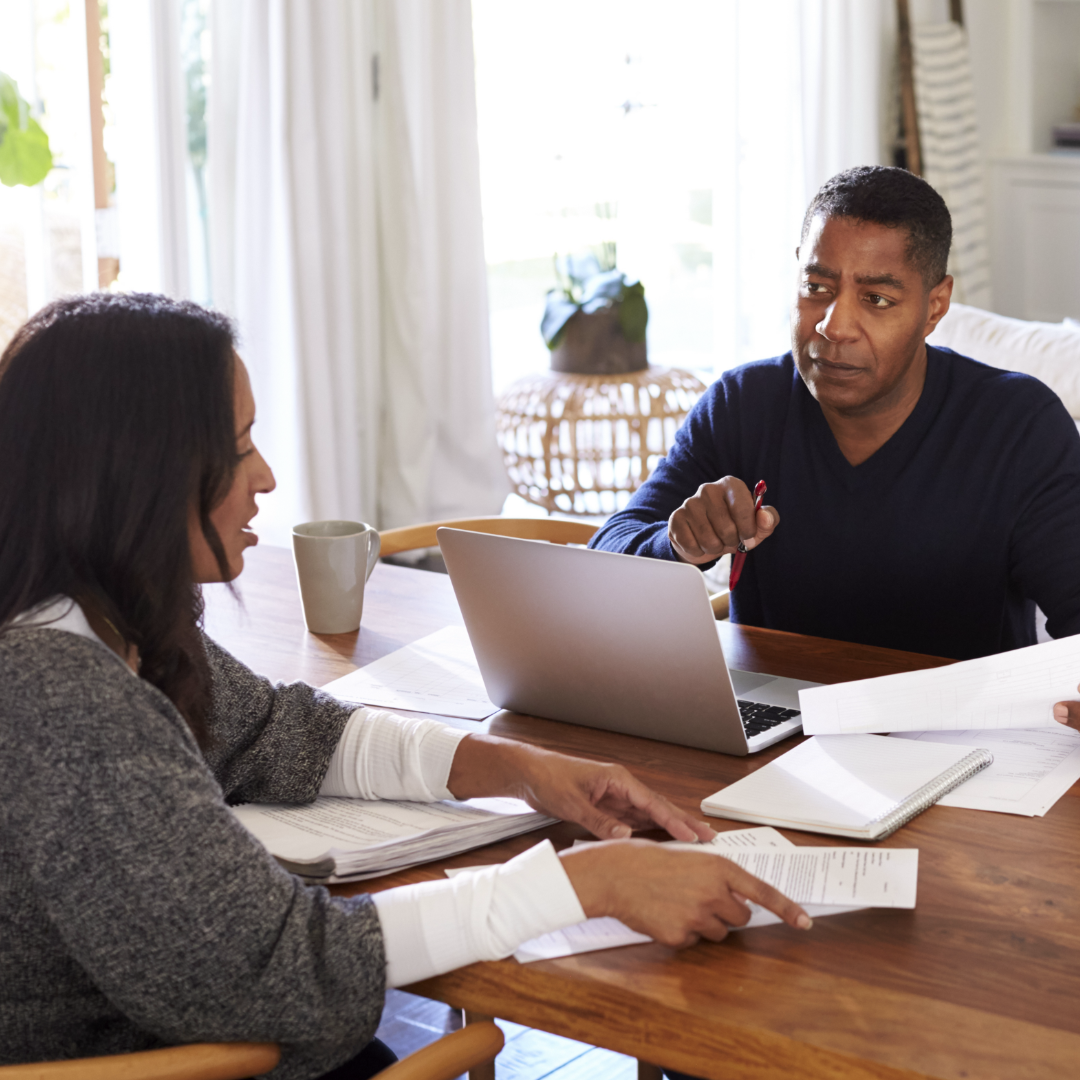 Couple discussing finances at kitchen table – 1